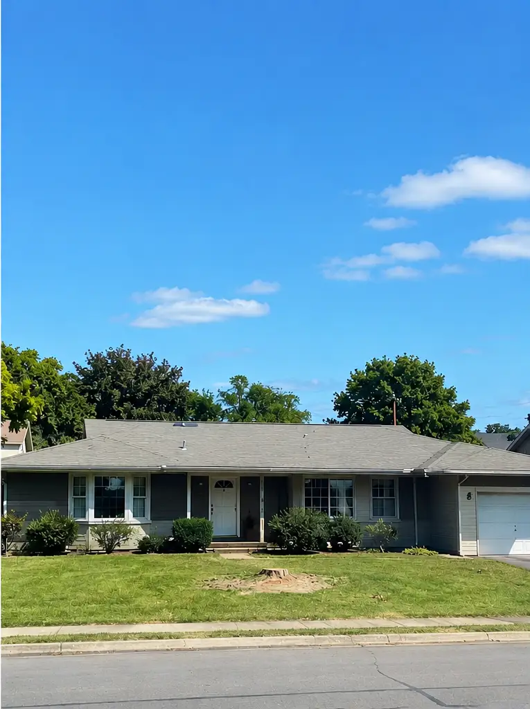 Same Albany NY residential property after tree removal, showing an open front yard with the tree removed and improved visibility of the home.
